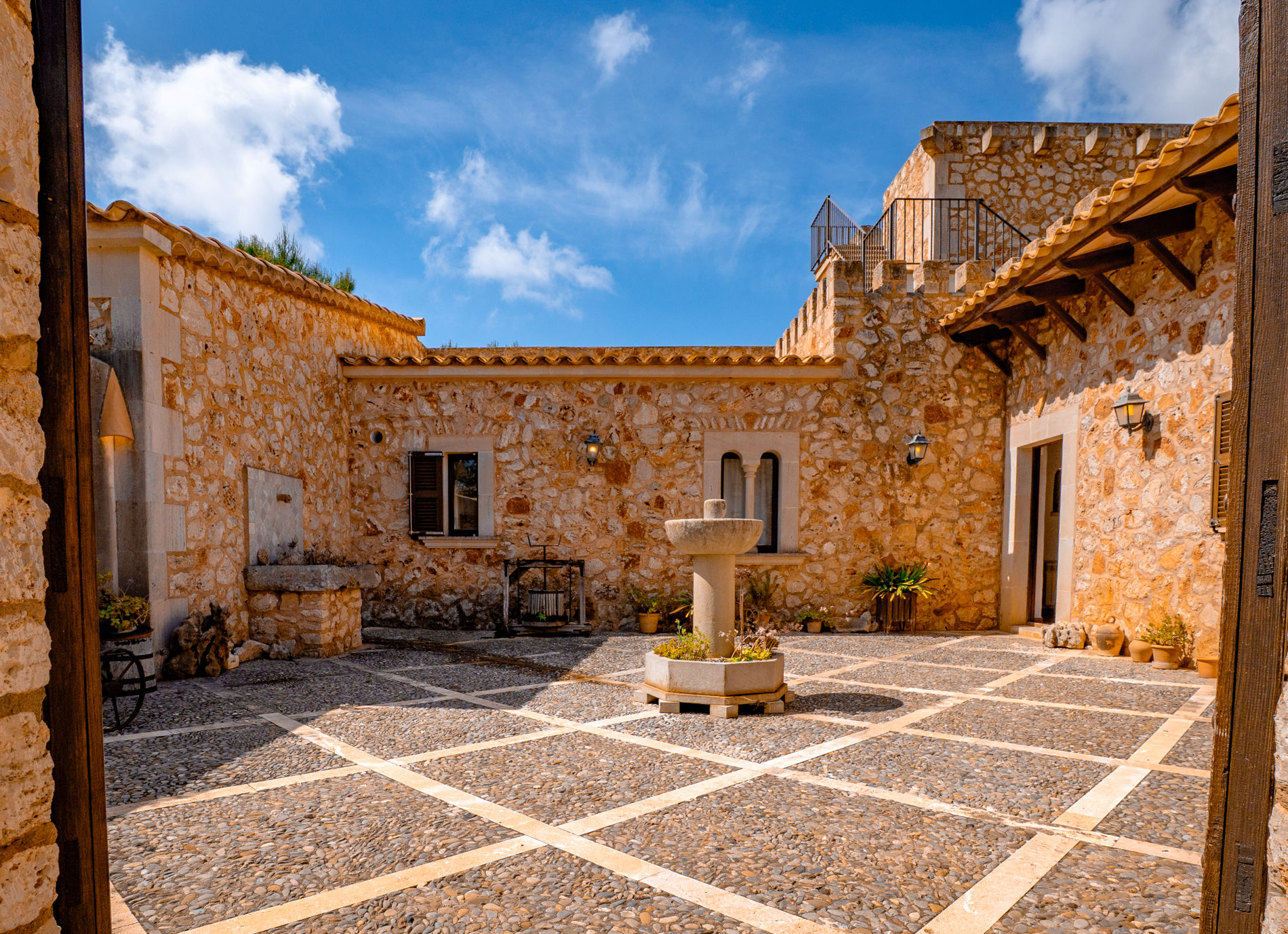 Patio interior mediterráneo de Finca Es Castell con fuente de piedra