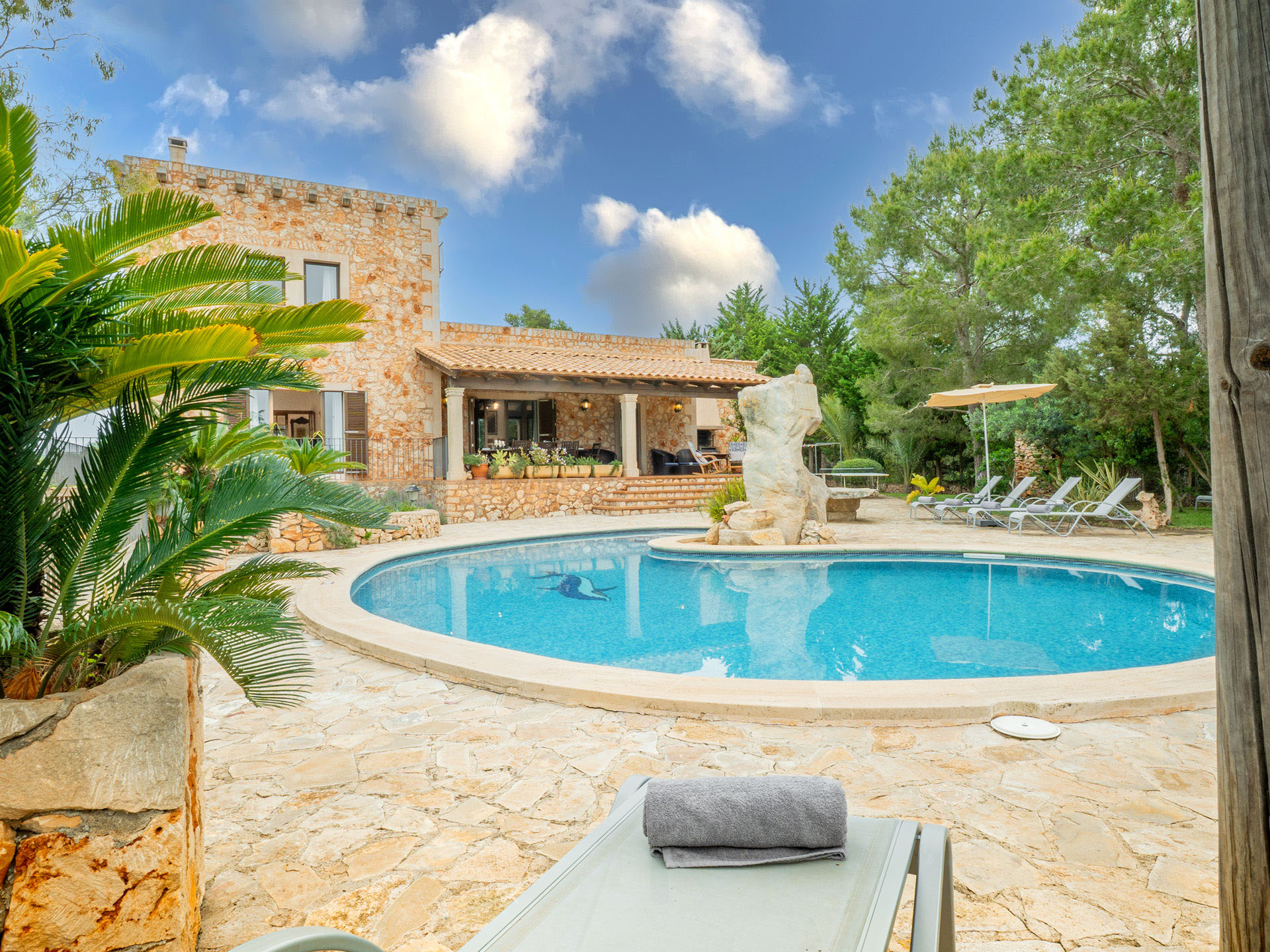 Piscina privada de Finca Es Castell con tumbonas y olivos